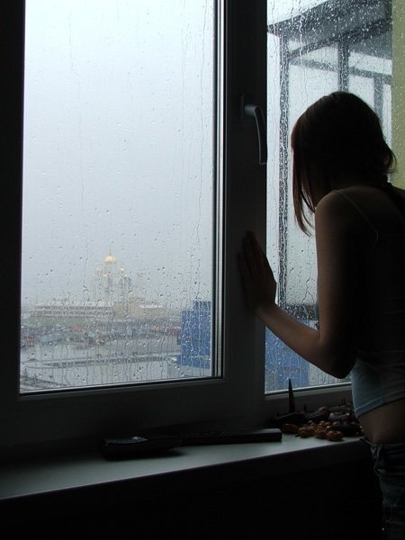 Одинокая дама в лифчике у окна